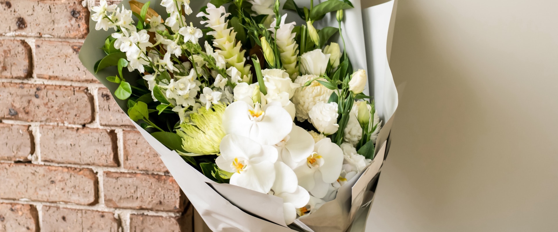 A bouquet of flowers delivered on a porch doorsteps of a house front door. Surprise contactless delivery. Mother's Day, Valentine's Day, Birthday, Celebration and Anniversary concept