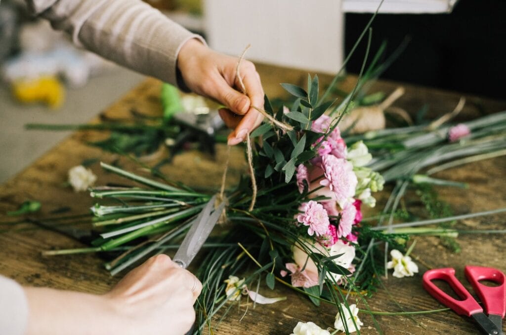 Девушка флорист собирает красивый букет girl florist makes a beautiful bouquet